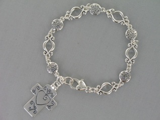 Celebrate a special occasion with our antique silver tone engravable hinged cross bracelet. Beautiful scroll and flower links attach with a lobster claw. The inside hing can be engraved with up to 7 characters in either a script font or block font.