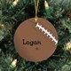 Enjoy watching all the holiday football games as your Personalized Football Ornament hangs handsomely on the Christmas tree. Personalized Football Christmas Ornaments make great stocking stuffers for all your sports fans and look great hanging from your tree year after year. Our Football Ceramic Ornament is a flat ornament and measures 2.75" in diameter. Each Ornament includes a ribbon loop to easily hang from your Christmas tree. Includes FREE Personalization! Personalized your Football ornament with any name.
